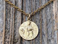 Shiny Gold St Dymphna Medallion dangling on a cable chain necklace
