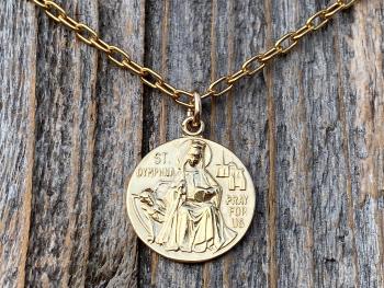Shiny Gold St Dymphna Medallion dangling on a cable chain necklace